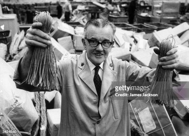 Bill Coogan of Mount Pleasant Post Office, London, holding up string used to secure parcels in the sorting office.
