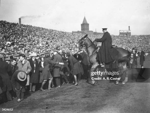 Mounted police push the crowd off the pitch during the FA Cup semi-final match between Sheffield Wednesday and Huddersfield at Manchester.