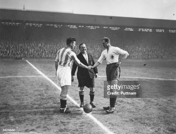 Huddersfield Town captain Wilson shakes hands with Bolton Wanderers captain James Seddon before the start of the FA Cup semi-final match at Liverpool.