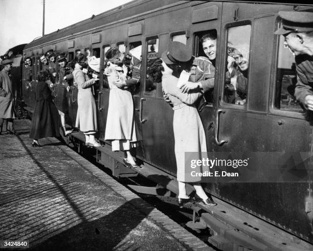 Soldiers kissing their sweethearts goodbye as troops leave for Egypt from Feltham Station.