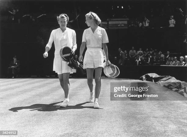 American tennis star Louise Brough, left, and A J Mottram walking onto court at Wimbledon.