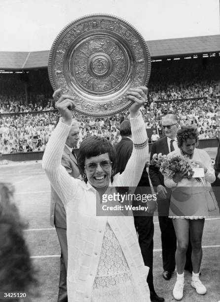 American tennis champion Billie Jean King holds her trophy aloft, after her win over Evonne Goolagong in the final of the Womens Singles at Wimbledon.