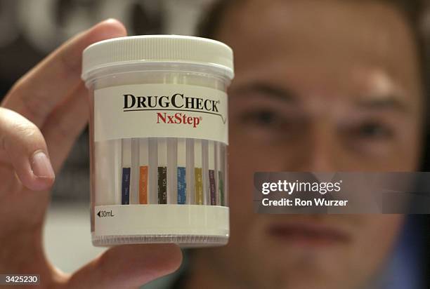 Patrick Beentjes of Scienta int'l inc, holds up urine container to be used for a drug test at the Drug & Alcohol Testing Industry Association annual...