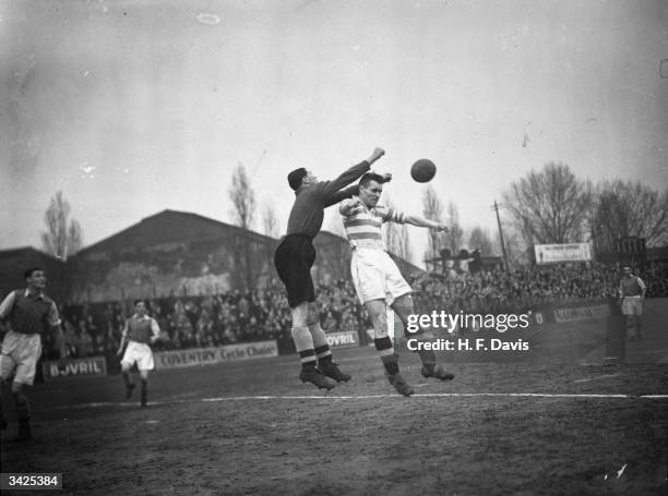 Arsenal goalkeeper Marks pushing the ball away from the head of Queen's Park Rangers forward Swinfen during a match at Loftus Road.