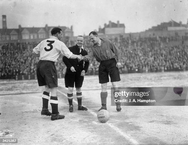 The captains of a Football Association XI and an Army XI shake hands before a game at Selhurst Park in London. Arsenal player Eddie Hapgood led the...