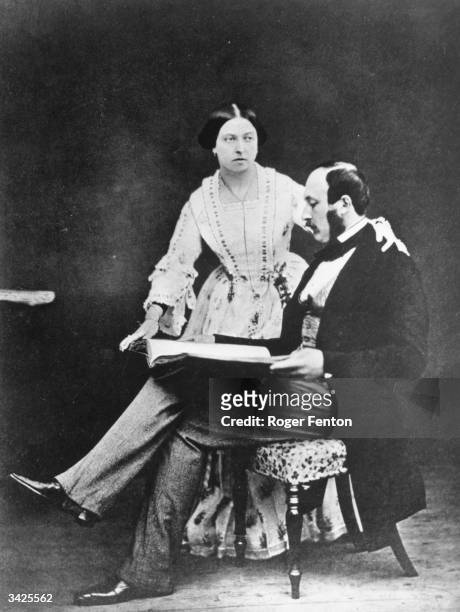 Queen Victoria with Prince Albert shortly before he went to the Crimea, 1854. Prince Albert is reading while Victoria stands beside him with a hand...