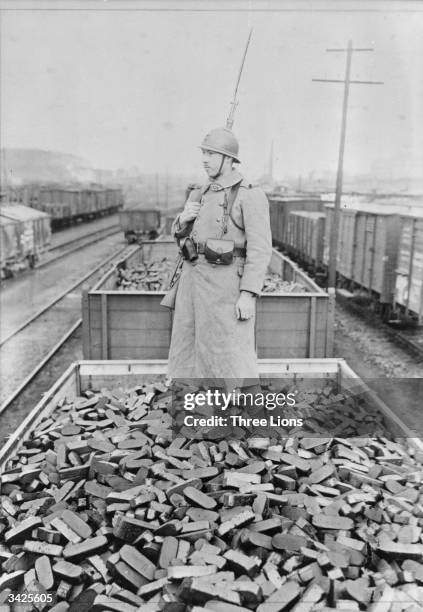 French soldier stands on a trainload of coke near Cologne. The shipment is part of the reparations paid to the French in coal and coke by Germany...