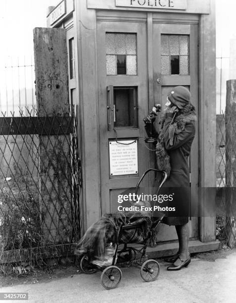 Woman uses an Emergency Police Call Box in London.
