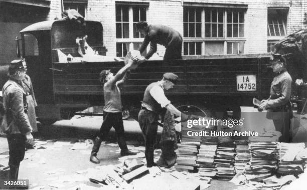 Nazi's supervising the loading of seized documents on to a lorry, following anti-Communist raids.