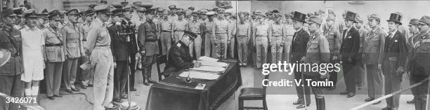 Russian representative Lt General K N Darevyanko signing the Act of Japan's capitulation in the presence of General MacArthur , and the Japanese...