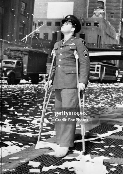 Wounded American serviceman during a ticker tape parade in New York following press reports of the unconditional surrender of Germany.