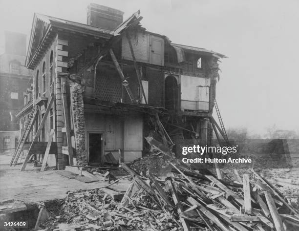 The ruins of the North East wing of Chelsea Hospital, London, bombed by a German airforce Zeppelin. An officer of the hospital staff, his wife, her...