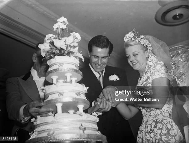 British actress Angela Lansbury and her husband, Peter Shaw, cutting the cake at their wedding.