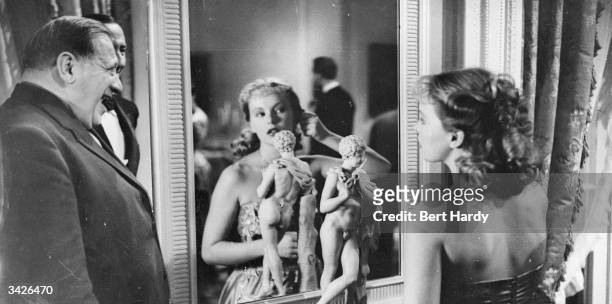 Director Gregory Ratoff watching actress Peggy Cummins applying her make up during the production of 'That Dangerous Age'. Original Publication:...