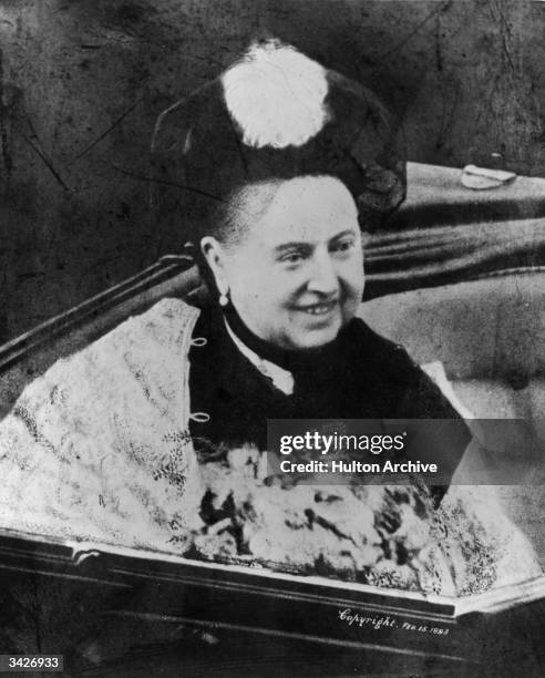 Smiling Queen Victoria in an open coach.