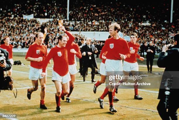 Ray Wilson performing a lap of honour with the Charlton brothers at Wembley after England won the World Cup against West Germany 4-2.