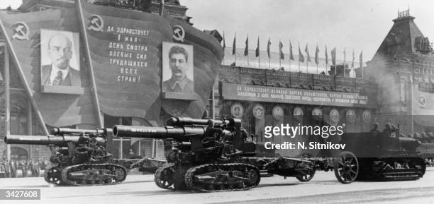 Heavy artillery on parade during a review of the Moscow Garrison troops during the May Day celebrations in Red Square, passing posters of Lenin and...