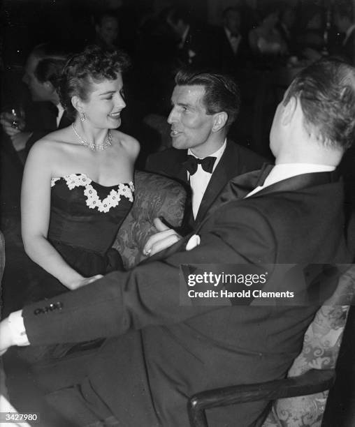 British actor Michael Rennie charms American actress Coleen Gray at a smart function.