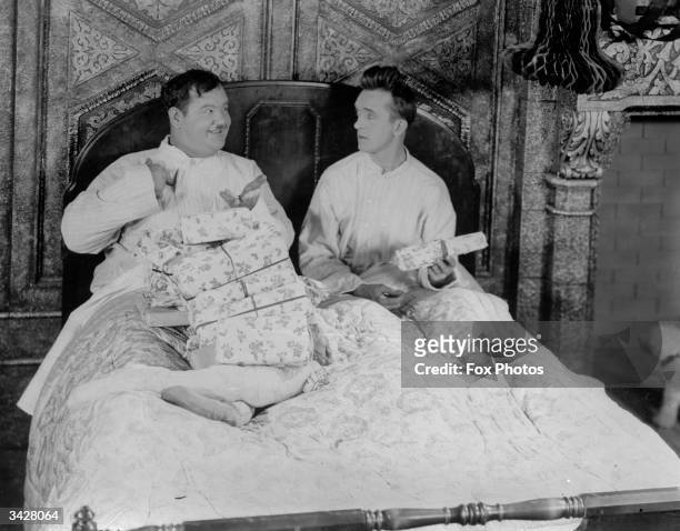 American comic duo Oliver Hardy and Stan Laurel exchanging gifts.