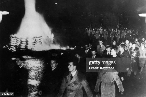 Crowds marching past piles of burning books in the Opernplatz in Berlin.