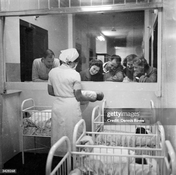 An observation window enables visiting fathers to look at their new-born offspring at the Maternity Ward of the North Shore Hospital in Sydney.