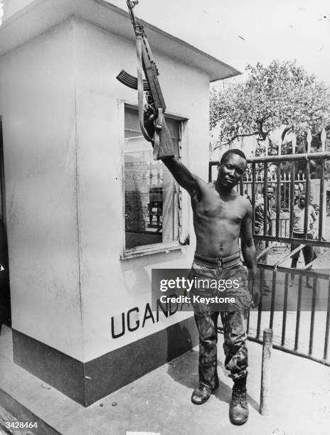 Tanzanian soldier waving his gun in victory on a border post at Busia after its capture from Idi Amin's troops.