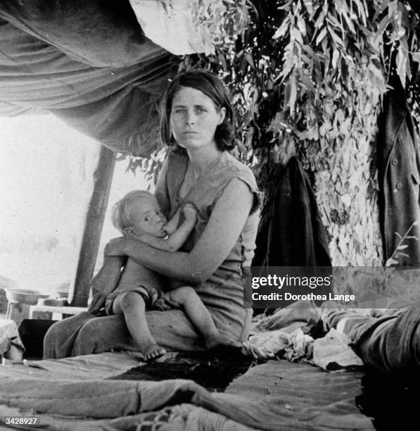 The mother of a migrant family from Oklahoma breastfeeds her child in a camp by the roadside in Blythe, California.