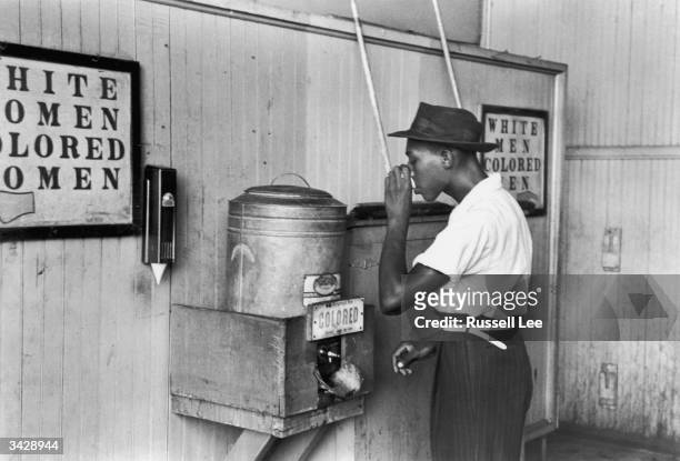 An African-American man drinking at a segregated drinking fountain in Oklahoma City, Oklahoma.