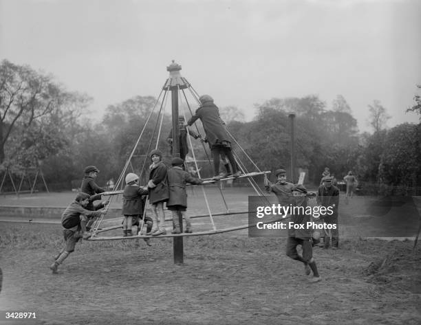 Having fun on a roundabout in the children's playground, Regent's Park, London.