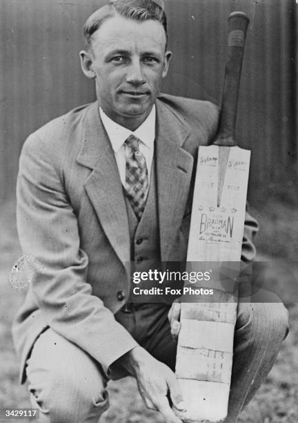 Australian batsman Don Bradman holding a personalized cricket bat.