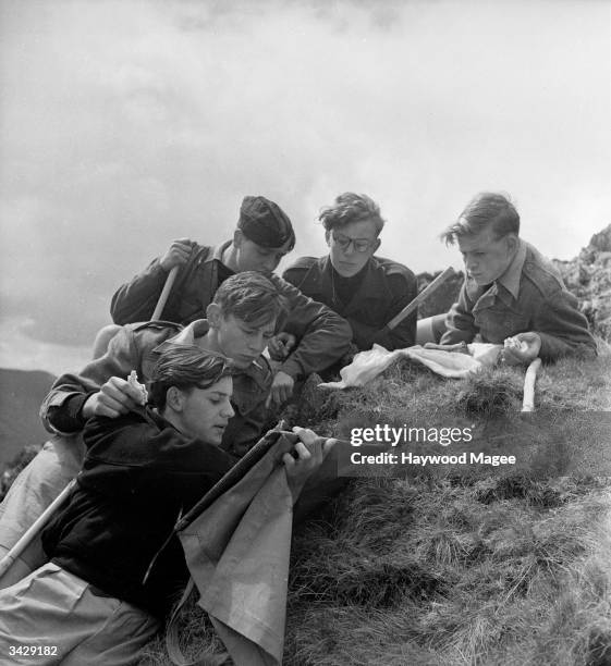 Billy Hinds, Spike Winn, Dieter Jung, Victor Horwood and John Patrick, students of the Aberdovey Outward Bound Sea School study their maps whilst on...