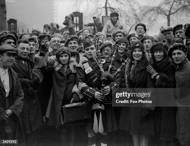 Bagpipe player leads a crowd of Scottish soccer fans through London.