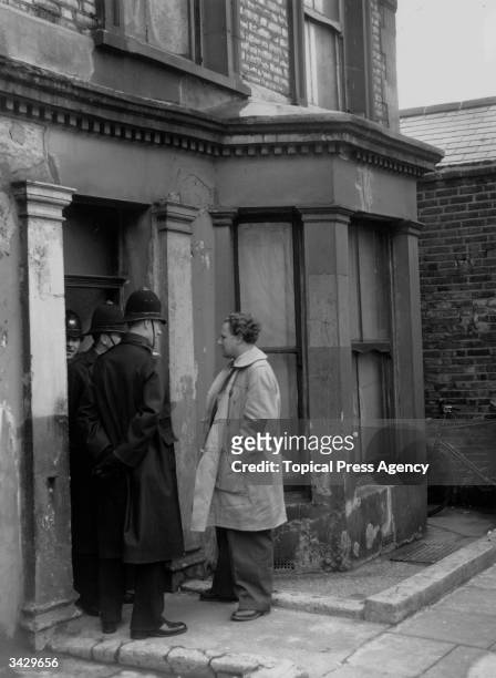 Policemen standing in the doorway of Number 10, Rillington Place, London, where serial killer John Reginald Christie lived and buried the bodies of...