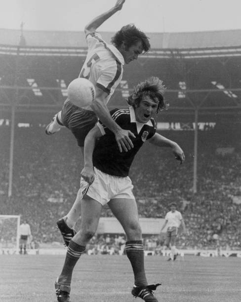 England's Dave Watson leaps above Scotland's Kenny Dalglish during their international football match at Wembley Stadium, London.