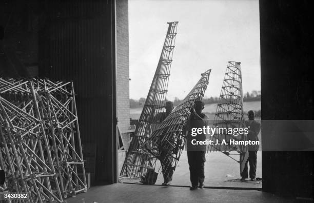 Fuselage fairings for Hawker 'Hurricane' fighters being carried into a factory. The work is part of Air Force expansion plans.