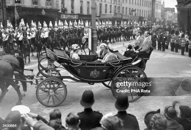 Princess Elizabeth and Princess Margaret travel in an open coach with Queen Ingrid of Denmark, as they proceed between Victoria Station and...
