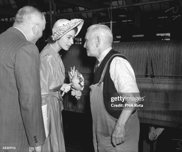 Princess Elizabeth chats to a workman at the Trafalgar Mills in Huddersfield, on the first day of her tour of West Riding in Yorkshire.