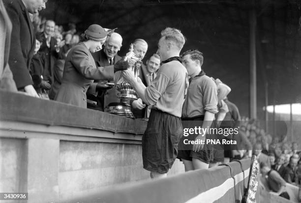 Princess Elizabeth presents Wolverhampton Wanderers team captain, Billy Wright, with the FA Cup trophy, after Wolves' 3-1 victory over Leicester City...