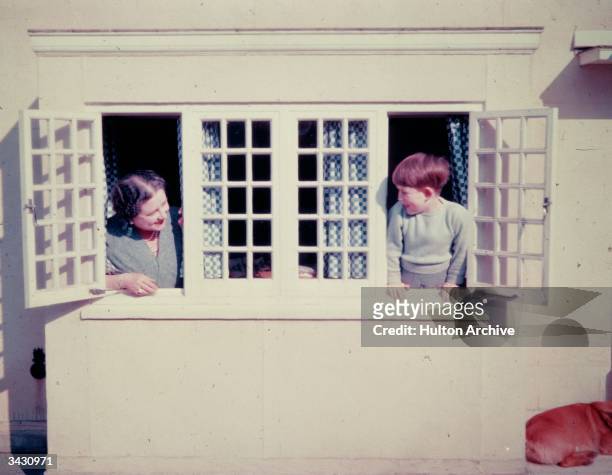 The Queen Mother playing with her grandson Prince Charles in the Little Welsh House at the Royal Lodge, Windsor.