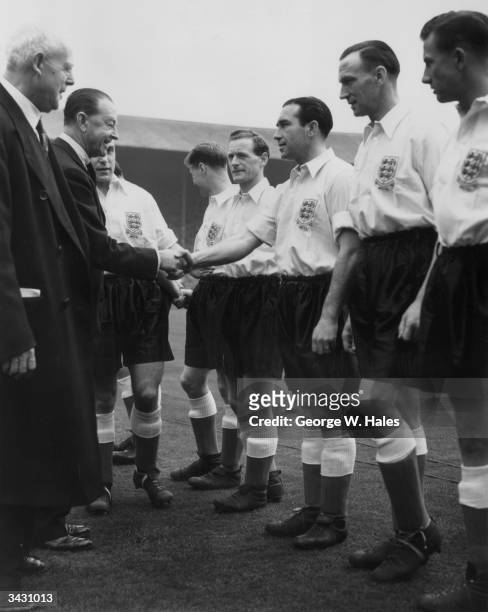 The captain of the England football team, Billy Wright, introducing Lord Alexander to members of the team, including Alf Ramsey and Tom Finney .