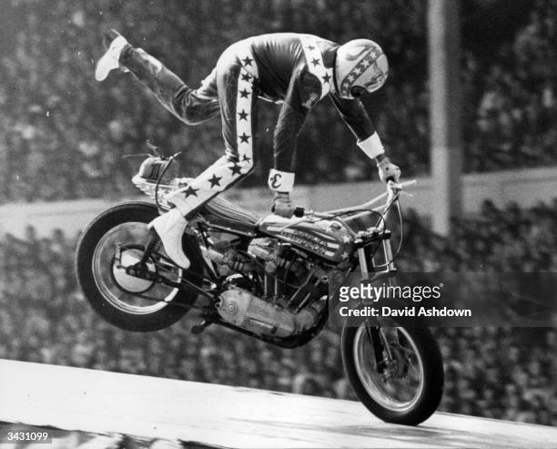 American stunt motorcyclist Evel Knievel coming in to land after a 90 mph leap over 13 single-deck buses to a crash landing in which he fractured his...
