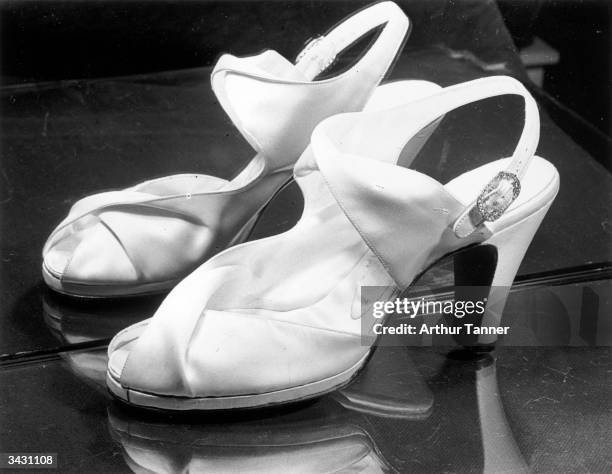 Shoes worn by Princess Elizabeth on her wedding day. Ivory duchesse satin self-lined, they are in one piece, embracing the waist of the foot with...