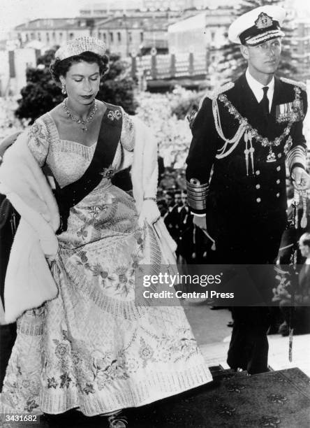 Queen Elizabeth II, wearing her Coronation dress, arriving with the Duke of Edinburgh to open Parliament in Wellington, New Zealand.