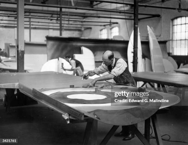 Workers at the Bristol Aeroplane Co works at Filton, Gloucester, spraying identification markings onto the wings of the Bristol Bulldog, an all steel...