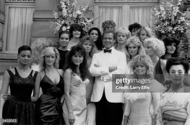 Film star Roger Moore and the Bond Girls from the film 'View to a Kill' directed by John Glen.