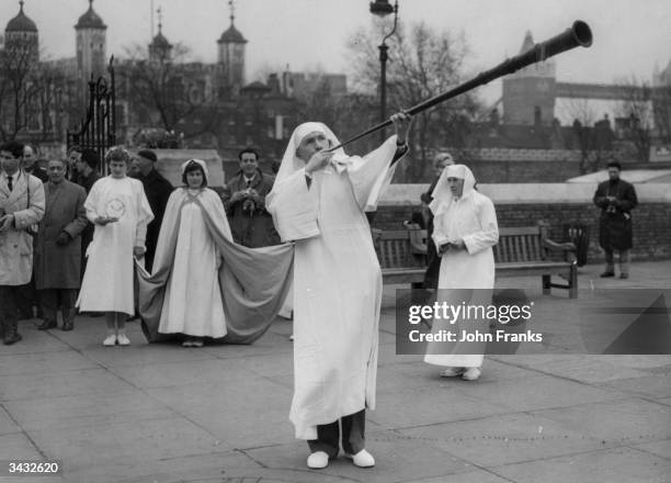 Member of the Ancient Order of Druids blowing a long horn to mark the Spring Equinox at Tower Hill in London.