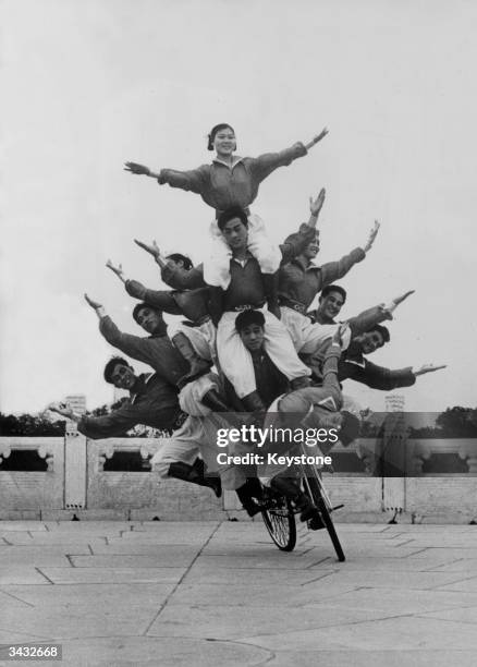 Ten Chinese acrobats balancing on a bicycle in Paris.