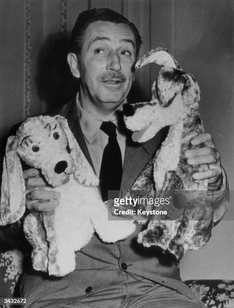 American cartoonist and film producer Walt Disney introducing his two new canine characters who star in his latest film 'The Lady And The Tramp'.