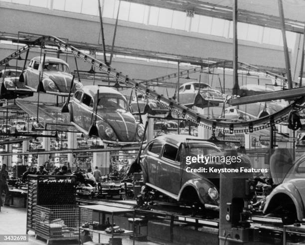 Production line manufacturing Volkswagen beetles at the factory in Wolfsburg, West Germany, 26th September 1956.