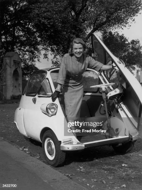 Actress Sally Bazely getting into a BMW Isetta at the Motor Show.